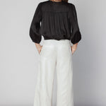 Pantalón Anise de la marca O-2025-812, pantalones de corte recto en color neutro, mostrado colgado en percha.